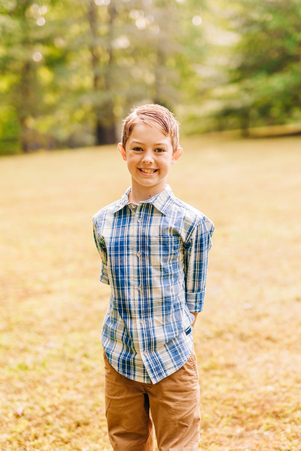 Young boy in plaid shirt smiling for portraits in Haymarket, VA