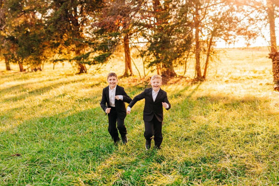 Young boys in suits running through a field at Manassas Battlefield Park