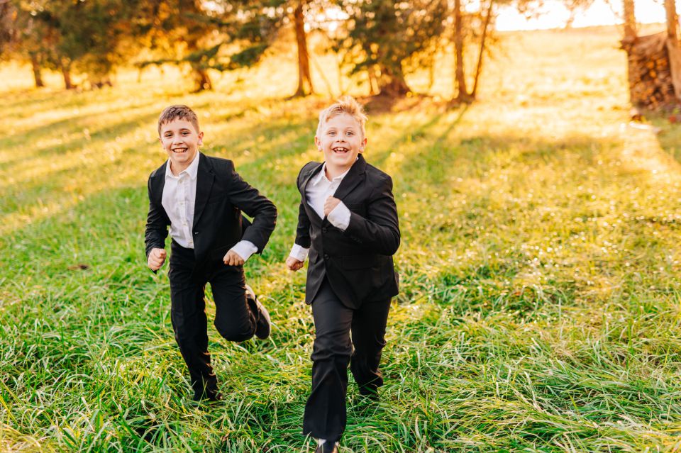Young boys in suits running through a field at Manassas Battlefield Park
