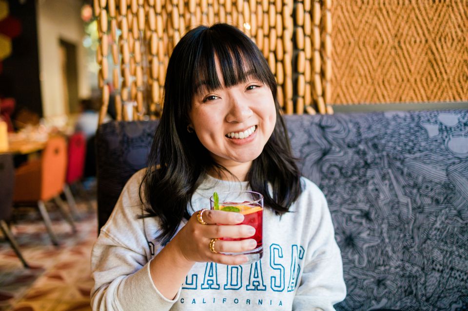 Young woman in white sweatshirt holding a glass of sangria