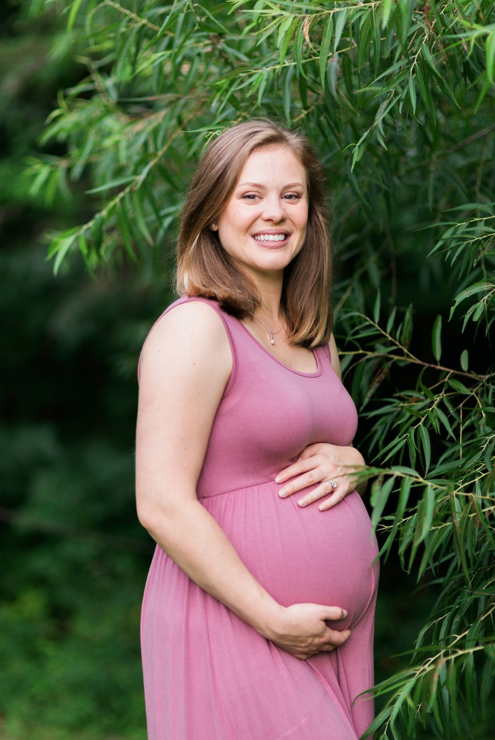 Pregnant woman smiling at Lake Mercer in Springfield, VA